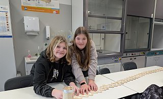 Elaine und Isabella bauen an ihrem Experiment. Nicht mehr lange und sie können loslassen, damit die Stäbchen auseinander springen. - Alex Wall Elaine und Isabella bauen an ihrem Experiment. Nicht mehr lange und sie können loslassen, damit die Stäbchen auseinander springen. - Alex Wall