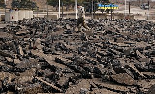 Ein Bauarbeiter geht über eine kaputte Straße vor dem Grenzübergang zwischen dem ukrainisch kontrollierten Gebiet und dem von prorussischen Separatisten kontrollierten Gebiet in Luhansk. - Foto: Vadim Ghirda/AP/dpa Ein Bauarbeiter geht über eine kaputte Straße vor dem Grenzübergang zwischen dem ukrainisch kontrollierten Gebiet und dem von prorussischen Separatisten kontrollierten Gebiet in Luhansk. - Foto: Vadim Ghirda/AP/dpa