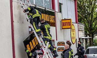 Feuerwehrleute entfernen unter Polizeischutz ein Schild am Vereinsheim der Rockergruppe «Bandidos». - Foto: Dieter Menne/dpa Feuerwehrleute entfernen unter Polizeischutz ein Schild am Vereinsheim der Rockergruppe «Bandidos». - Foto: Dieter Menne/dpa