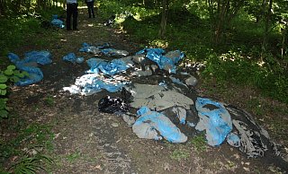 Die entsorgten Müllsäcke mit Schlamm im Wald. - Polizei Die entsorgten Müllsäcke mit Schlamm im Wald. - Polizei