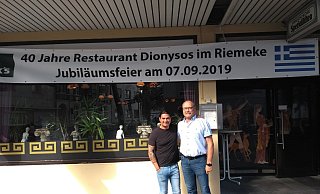 Gäste des Restaurants haben sich um Gerhard Hüllweg (r.) zusammen getan und überzeugten den Inhaber Konstantinos Karamihailidis (l.) von den Feierlichkeiten. - Moritz Jülich Gäste des Restaurants haben sich um Gerhard Hüllweg (r.) zusammen getan und überzeugten den Inhaber Konstantinos Karamihailidis (l.) von den Feierlichkeiten. - Moritz Jülich