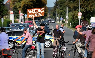 Ingold Klee steigt in Ummeln von seinem Fahrrad, holt ein Schild vom Gepäckträger und fordert alle 2.000 Protestanten zur "Verkehrswende" auf. - Andreas Frücht Ingold Klee steigt in Ummeln von seinem Fahrrad, holt ein Schild vom Gepäckträger und fordert alle 2.000 Protestanten zur "Verkehrswende" auf. - Andreas Frücht