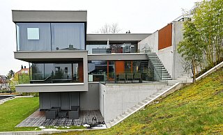 Von der Gartenseite zeigt sich die Raffinesse der Architektur: Asymmetrisch ineinander geschobene Kuben, die sich über drei Stockwerke erstrecken und umlaufende große Glasfronten auf jeder Etage formen die Gestalt des Hauses. - Barbara Franke Von der Gartenseite zeigt sich die Raffinesse der Architektur: Asymmetrisch ineinander geschobene Kuben, die sich über drei Stockwerke erstrecken und umlaufende große Glasfronten auf jeder Etage formen die Gestalt des Hauses. - Barbara Franke