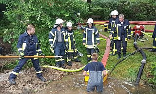 Neben der Rohrbruchstelle wird der Saugkorb der XXL-Pumpe des Hytrans Fire Systems in Stellung gebracht. Im Hintergrund liegen bereits die roten 150 Millimeter messenden F-Schläuche. - Feuerwehr Lichtenau Neben der Rohrbruchstelle wird der Saugkorb der XXL-Pumpe des Hytrans Fire Systems in Stellung gebracht. Im Hintergrund liegen bereits die roten 150 Millimeter messenden F-Schläuche. - Feuerwehr Lichtenau