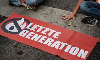 Ein Aktivist der Gruppe «Letzte Generation» blockiert eine Kreuzung. - Swen Pförtner/dpa/Symbolbild Ein Aktivist der Gruppe «Letzte Generation» blockiert eine Kreuzung. - Swen Pförtner/dpa/Symbolbild