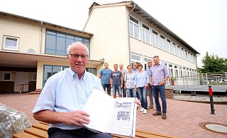 Hans-Josef Held (vorn) zeigt die entscheidende Seite in der Godelheimer Chronik, in der über die Eröffnung der Schule berichtet wird. Zum runden Geburtstag planen er und seine Mitstreiter ein buntes Fest. - David Schellenberg Hans-Josef Held (vorn) zeigt die entscheidende Seite in der Godelheimer Chronik, in der über die Eröffnung der Schule berichtet wird. Zum runden Geburtstag planen er und seine Mitstreiter ein buntes Fest. - David Schellenberg