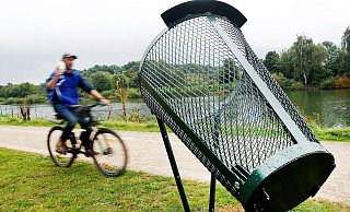 Ein Fahrradfahrer wirft am Rhein-Herne-Kanal seinen Müll im Vorbeifahren in einen der neuen Wurfmülleimer. - picture alliance/dpa Ein Fahrradfahrer wirft am Rhein-Herne-Kanal seinen Müll im Vorbeifahren in einen der neuen Wurfmülleimer. - picture alliance/dpa