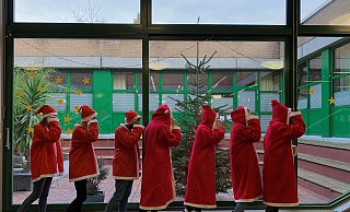 EIn lange Schlange von Nikoläusen spaziert duch das Eingangsfoyer des Gymnasiums aufd er Hüffert. - Hüffertgymnasium EIn lange Schlange von Nikoläusen spaziert duch das Eingangsfoyer des Gymnasiums aufd er Hüffert. - Hüffertgymnasium