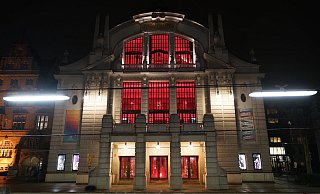 Das Stadttheater ist am Aktionstag der Theater und Orchester von innen rot beleuchtet. „Wir sind da", so die Botschaft. - Peter Unger Das Stadttheater ist am Aktionstag der Theater und Orchester von innen rot beleuchtet. „Wir sind da", so die Botschaft. - Peter Unger