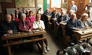 Die Gruppe der früheren Schülerinnen und Schüler nahm brav in der Klasse Platz. Anton Hillebrand (stehend) vom Bernhard-Wolff-Schulmuseum sorgte dafür, dass viele Erinnerungen aufgefrischt wurden. - Johannes Büttner Die Gruppe der früheren Schülerinnen und Schüler nahm brav in der Klasse Platz. Anton Hillebrand (stehend) vom Bernhard-Wolff-Schulmuseum sorgte dafür, dass viele Erinnerungen aufgefrischt wurden. - Johannes Büttner