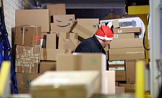 In einer Zustellbasis von DHL wird ein LKW mit Paketen entladen. - Bernd Wüstneck/dpa In einer Zustellbasis von DHL wird ein LKW mit Paketen entladen. - Bernd Wüstneck/dpa