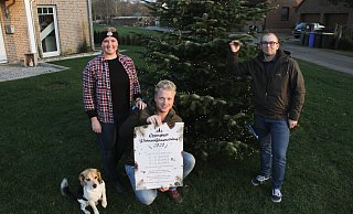 Am Tannenbaum im Vorgarten die Lichter brennen: Sophia Weymann (v. l.), Tristan Wiemers und Dennis Kirchner mit dem Werbeplakat zum „Ossendorfer Weihnachtsbaumverkauf". - Dieter Scholz Am Tannenbaum im Vorgarten die Lichter brennen: Sophia Weymann (v. l.), Tristan Wiemers und Dennis Kirchner mit dem Werbeplakat zum „Ossendorfer Weihnachtsbaumverkauf". - Dieter Scholz