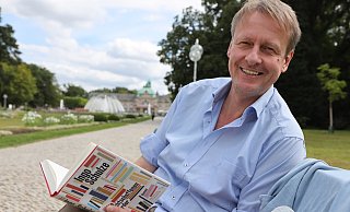 Michael Scholz, Organisator der Poetischen Quellen, mit dem aktuellen Buch von Ingo Schulze im Kurpark Bad Oeynhausen. - Jörg Stuke Michael Scholz, Organisator der Poetischen Quellen, mit dem aktuellen Buch von Ingo Schulze im Kurpark Bad Oeynhausen. - Jörg Stuke