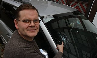 Stephan Aggen zeigt vor seiner Wohnung am Johannisturm auf das Loch in der Windschutzscheibe seines Autos. Er hat es abgeklebt. - Dieter Scholz Stephan Aggen zeigt vor seiner Wohnung am Johannisturm auf das Loch in der Windschutzscheibe seines Autos. Er hat es abgeklebt. - Dieter Scholz