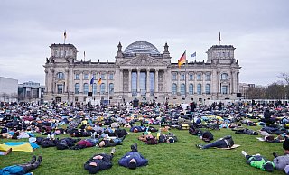 Liegender Protest vor dem Reichstagsgebäude in Berlin. - Foto: Annette Riedl/dpa Liegender Protest vor dem Reichstagsgebäude in Berlin. - Foto: Annette Riedl/dpa