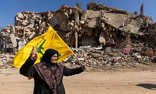 Eine libanesische Frau hält eine Hisbollah-Fahne in ihrem von der israelischen Luft- und Bodenoffensive zerstörten Dorf im Südlibanon. Laut NRW-Verfassungsschutz leben Anhänger der in Deutschland verbotenen Terrororganisation auch in Bad Oeynhausen. - Hassan Ammar/AP/dpa Eine libanesische Frau hält eine Hisbollah-Fahne in ihrem von der israelischen Luft- und Bodenoffensive zerstörten Dorf im Südlibanon. Laut NRW-Verfassungsschutz leben Anhänger der in Deutschland verbotenen Terrororganisation auch in Bad Oeynhausen. - Hassan Ammar/AP/dpa