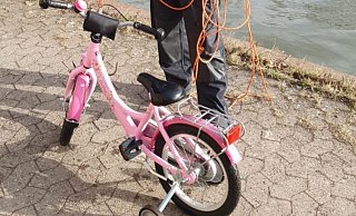Ein Polizist steht am Mittellandkanal in Minden neben einem Kinderrad. Es war einer Vierjährigen ins Wasser gefallen. Foto: Polizei Duisburg/dpa - Polizei Duisburg Ein Polizist steht am Mittellandkanal in Minden neben einem Kinderrad. Es war einer Vierjährigen ins Wasser gefallen. Foto: Polizei Duisburg/dpa - Polizei Duisburg