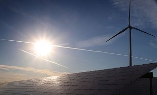 Ein Windrad steht hinter den Solarzellen einer Solarkraftanlage im Sonnenschein. - Foto: Karl-Josef Hildenbrand/dpa Ein Windrad steht hinter den Solarzellen einer Solarkraftanlage im Sonnenschein. - Foto: Karl-Josef Hildenbrand/dpa