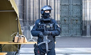 Vor dem Pontifikalamt im Kölner Dom zum Jahresabschluss mit Kardinal Woelki wird das Domumfeld von Einsatzkräften der Polizei mit Maschinenpistolen stark bewacht. - Thomas Banneyer/dpa Vor dem Pontifikalamt im Kölner Dom zum Jahresabschluss mit Kardinal Woelki wird das Domumfeld von Einsatzkräften der Polizei mit Maschinenpistolen stark bewacht. - Thomas Banneyer/dpa