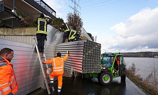 Feuerwehrleute bauen am Rheinufer bei Koblenz eine mobile Hochwasserschutzmauer auf. - picture alliance/dpa Feuerwehrleute bauen am Rheinufer bei Koblenz eine mobile Hochwasserschutzmauer auf. - picture alliance/dpa