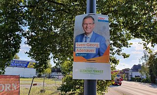 Auch an der Berliner Straße wurden mehrere Wahlplakate von Sven-Georg Adenauer mit dem Zusatz „Präsentiert von Clemens Tönnies" versehen. - Irja Most Auch an der Berliner Straße wurden mehrere Wahlplakate von Sven-Georg Adenauer mit dem Zusatz „Präsentiert von Clemens Tönnies" versehen. - Irja Most