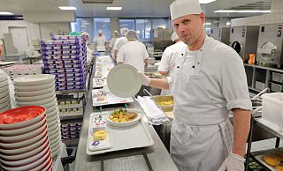 Küchenmeister Peter Thomas schaut sich bei der Endkontrolle jeden Teller, der vom Fließband kommt, an. - Frank-Michael Kiel-Steinkamp Küchenmeister Peter Thomas schaut sich bei der Endkontrolle jeden Teller, der vom Fließband kommt, an. - Frank-Michael Kiel-Steinkamp
