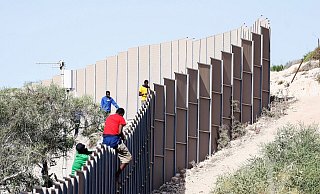 Migranten klettern über einen Zaun auf der italienischen Insel Lampedusa. - Cecilia Fabiano/LaPresse via ZUMA Press/dpa Migranten klettern über einen Zaun auf der italienischen Insel Lampedusa. - Cecilia Fabiano/LaPresse via ZUMA Press/dpa