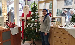 Mitarbeiterin Zanife Güngör steht vor dem Wunschbaum im sozialen Kaufhaus „einLaden“. Güngör trägt nur wegen des Fotos keine Maske. Ansonsten herrscht Maskenpflicht im Sozialkaufhaus, und es wird auf die Einhaltung der vorgeschriebenen Abstände geachtet. - Soziales Kaufhaus "einLaden" Mitarbeiterin Zanife Güngör steht vor dem Wunschbaum im sozialen Kaufhaus „einLaden“. Güngör trägt nur wegen des Fotos keine Maske. Ansonsten herrscht Maskenpflicht im Sozialkaufhaus, und es wird auf die Einhaltung der vorgeschriebenen Abstände geachtet. - Soziales Kaufhaus "einLaden"