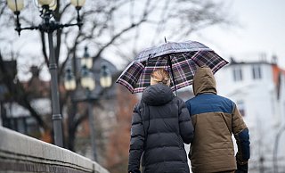 Spaziergänger laufen mit Schirm über eine Brücke in Hamburg. - Jonas Walzberg/dpa Spaziergänger laufen mit Schirm über eine Brücke in Hamburg. - Jonas Walzberg/dpa