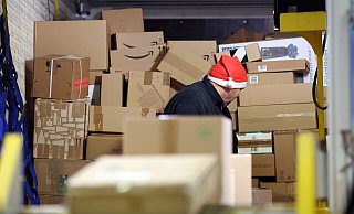 In einer DHL-Zustellbasis wird ein Lkw mit Paketen entladen, um sie auf die Zustellfahrzeuge aufzuteilen. - Bernd Wüstneck/dpa In einer DHL-Zustellbasis wird ein Lkw mit Paketen entladen, um sie auf die Zustellfahrzeuge aufzuteilen. - Bernd Wüstneck/dpa