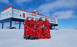 Das neunköpfige Überwinterungsteam posiert vor der Forschungsstation Neumayer III in der Antarktis. - Markus Baden/AWI/dpa Das neunköpfige Überwinterungsteam posiert vor der Forschungsstation Neumayer III in der Antarktis. - Markus Baden/AWI/dpa