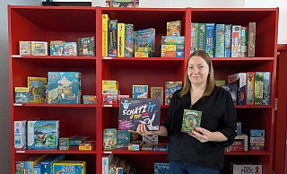 Corinna Grundmann präsentiert vor dem prall gefüllten Spieleregal der Stadtbücherei einige ihrer Empfehlungen für jung und alt. - Alex Wall Corinna Grundmann präsentiert vor dem prall gefüllten Spieleregal der Stadtbücherei einige ihrer Empfehlungen für jung und alt. - Alex Wall