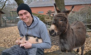 So könnte es mal aussehen: Tierpfleger-Azubi Marcel Ibers krault ein Minischwein-Ferkel - und Eseldame Mia schaut zu. - Birgit Vredenburg So könnte es mal aussehen: Tierpfleger-Azubi Marcel Ibers krault ein Minischwein-Ferkel - und Eseldame Mia schaut zu. - Birgit Vredenburg