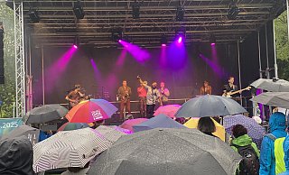 Fatcat-Sänger Kenny Joyner sorgt für Stimmung beim Paderborner Publikum, das mit Regenschirmen bestens gegen das miese Wetter gewappnet ist. - Julia Spiekerkötter Fatcat-Sänger Kenny Joyner sorgt für Stimmung beim Paderborner Publikum, das mit Regenschirmen bestens gegen das miese Wetter gewappnet ist. - Julia Spiekerkötter