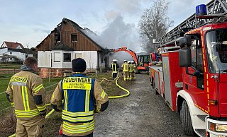 Ein Bagger reißt Teile des unbewohnten Gebäudes ein, damit die Feuerwehr Warburg erfolgreich löschen kann. - Freiwillige Feuerwehr Ein Bagger reißt Teile des unbewohnten Gebäudes ein, damit die Feuerwehr Warburg erfolgreich löschen kann. - Freiwillige Feuerwehr