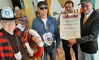 Stilecht mit Rettungsring und fescher Sonnenbrille: Zeremonienmeister Rudi Ryll (v. l.), Titgenbürger 2025 Stefan Bosse. Michael Artus und Präsident Michael Hendker vom Warburger Meister- und Gesellenverein überreichen die Urkunde. - Dieter Scholz Stilecht mit Rettungsring und fescher Sonnenbrille: Zeremonienmeister Rudi Ryll (v. l.), Titgenbürger 2025 Stefan Bosse. Michael Artus und Präsident Michael Hendker vom Warburger Meister- und Gesellenverein überreichen die Urkunde. - Dieter Scholz