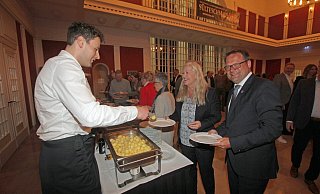 Bürgermeister Lars Bökenkröger (r.) und seine Partnerin Manuela Mundt stehen Schlange für den Grünkohl. Nils Torbrügge (l.), Geschäftsführer von GWD Minden, befüllt die Teller. - Ulf Hanke Bürgermeister Lars Bökenkröger (r.) und seine Partnerin Manuela Mundt stehen Schlange für den Grünkohl. Nils Torbrügge (l.), Geschäftsführer von GWD Minden, befüllt die Teller. - Ulf Hanke