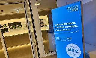Die blaue Werbetafel der neuen Airline steht im Aufgang zum Sitzungssal des Kreishauses in der Paderborner Aldegreverstraße. - Jens Reddeker Die blaue Werbetafel der neuen Airline steht im Aufgang zum Sitzungssal des Kreishauses in der Paderborner Aldegreverstraße. - Jens Reddeker