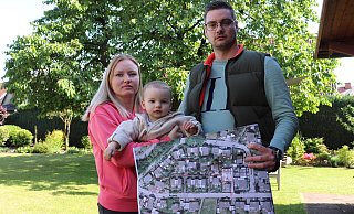 Pia Breimann und Daniel Pohlmann zeigen mit ihrem 14 Monate alten Sohn Luis auf einem Plan, dass auf der anderen Seite des Burgwegs in zweiter Reihe Häuser gebaut wurden. - Marion Pokorra-Brockschmidt Pia Breimann und Daniel Pohlmann zeigen mit ihrem 14 Monate alten Sohn Luis auf einem Plan, dass auf der anderen Seite des Burgwegs in zweiter Reihe Häuser gebaut wurden. - Marion Pokorra-Brockschmidt