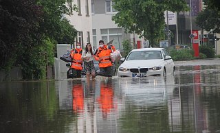 Anfang Juni 2021 hatten auch Bünde und Enger mit Wassermassen zu kämpfen. Feuerwehrmänner begleiten eine Frau durch das Hochwasser an der Engerstraße in Bünde. - Florian Weyand Anfang Juni 2021 hatten auch Bünde und Enger mit Wassermassen zu kämpfen. Feuerwehrmänner begleiten eine Frau durch das Hochwasser an der Engerstraße in Bünde. - Florian Weyand