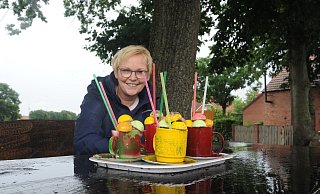 Auch bei Regen ist die bunte Deko auf dem Tisch der Sitzgruppe an der Varler Friedenseiche ein Blickfang. Über die als Cocktails gestaltete Deko im Dorf freut sich auch Ortsvorsteherin Anette Streich. - Joern Spreen-Ledebur Auch bei Regen ist die bunte Deko auf dem Tisch der Sitzgruppe an der Varler Friedenseiche ein Blickfang. Über die als Cocktails gestaltete Deko im Dorf freut sich auch Ortsvorsteherin Anette Streich. - Joern Spreen-Ledebur