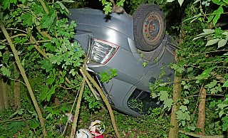 Hinter Bäumen versteckt und von der Straße nicht einsehbar war der Opel Astra mit beiden Insassen in einem Waldstück neben der Haaerener Straße auf dem Dach liegen geblieben. - Ralph Meyer Hinter Bäumen versteckt und von der Straße nicht einsehbar war der Opel Astra mit beiden Insassen in einem Waldstück neben der Haaerener Straße auf dem Dach liegen geblieben. - Ralph Meyer