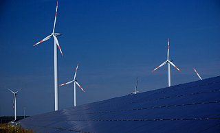 Windräder zur Stromerzeugung drehen sich in Mecklenburg-Vorpommern hinter einem Solarpark. - Foto: Jens Büttner/dpa-Zentralbild/dpa Windräder zur Stromerzeugung drehen sich in Mecklenburg-Vorpommern hinter einem Solarpark. - Foto: Jens Büttner/dpa-Zentralbild/dpa