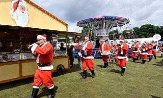 Eine holländische Musikkapelle in Weihnachtsmann-Kostümen spielt auf dem Weihnachtsmarkt in Solingen. - Foto: Roberto Pfeil/dpa Eine holländische Musikkapelle in Weihnachtsmann-Kostümen spielt auf dem Weihnachtsmarkt in Solingen. - Foto: Roberto Pfeil/dpa