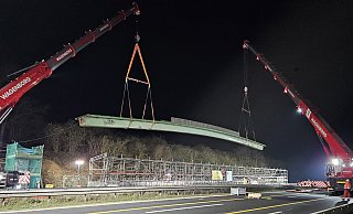 Ende 2024 wird die Schnapsbrücke mithilfe zweier Schwerlastkräne aus ihrer Verankerung gehoben und zur Reparatur an den Rand der A2 abgelegt. - Autobahn Westfalen/eberhardt – die ingenieure Ende 2024 wird die Schnapsbrücke mithilfe zweier Schwerlastkräne aus ihrer Verankerung gehoben und zur Reparatur an den Rand der A2 abgelegt. - Autobahn Westfalen/eberhardt – die ingenieure