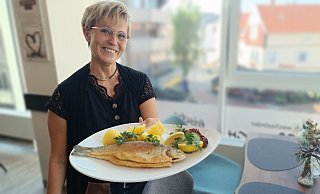 Freitags ist Fischtag im BüCafé: Andrea Finkemeyer mit einer ganzen Forelle, die es im Mittagsangebot für 12,90 Euro gibt. - Sven Hauhart Freitags ist Fischtag im BüCafé: Andrea Finkemeyer mit einer ganzen Forelle, die es im Mittagsangebot für 12,90 Euro gibt. - Sven Hauhart